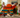 Two girls and an adult building a giant rainbow dinosaur with jumbo Biggo Blocks, using extra large building blocks for collaborative STEM learning and creative play indoors.