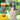 A young girl proudly stands next to a colorful structure built with Biggo Blocks in a sunny backyard.
