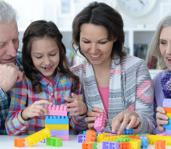 Grandparents and grandchildren bond over creative play with building blocks, sharing smiles and stories while stacking colorful blocks together.