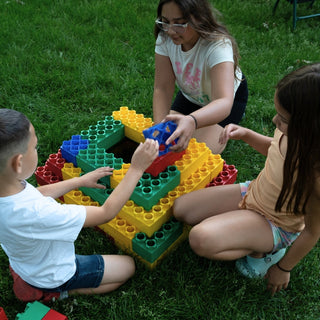 Kids playing outdoors with jumbo building blocks from Biggo Blocks. 