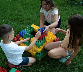 Kids playing outdoors with jumbo building blocks from Biggo Blocks. 