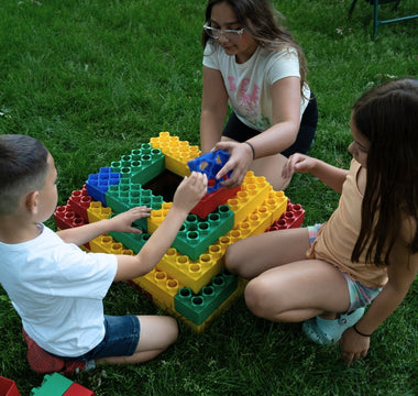 Kids playing outdoors with jumbo building blocks from Biggo Blocks. 