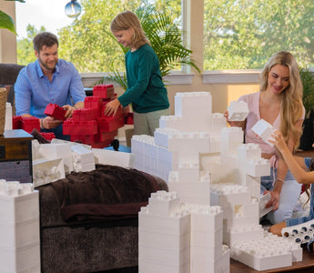 Family having fun with white jumbo building blocks.