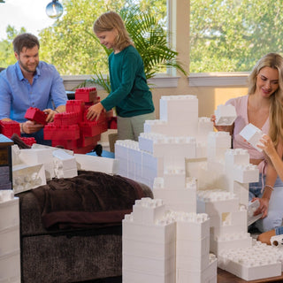 Family having fun with white jumbo building blocks.