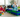 Three young children sitting on the floor, engaging in creative play with colorful building blocks in a cozy living room setting.