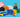 A colorful arrangement of new orange, black, and white Biggo Blocks, with a child seated beside the blocks. The display also features various single color sets and train sets, promoting the new product arrivals from Biggo Blocks.