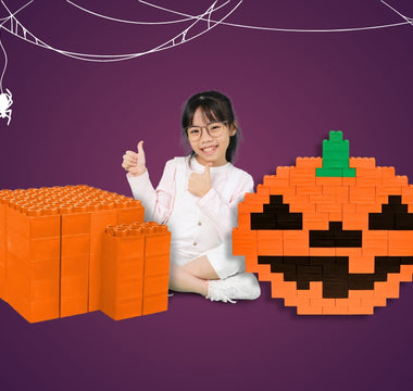 Image of a girl with a 49-piece orange Biggo Blocks kit and Halloween pumpkin build with Biggo Blocks. 